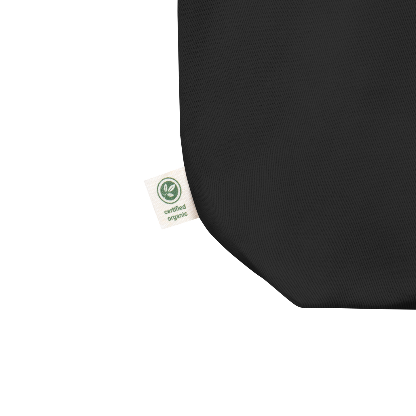 Black Outrageous slogan embroidered organic eco tote bag on a blank surface close up of the label.