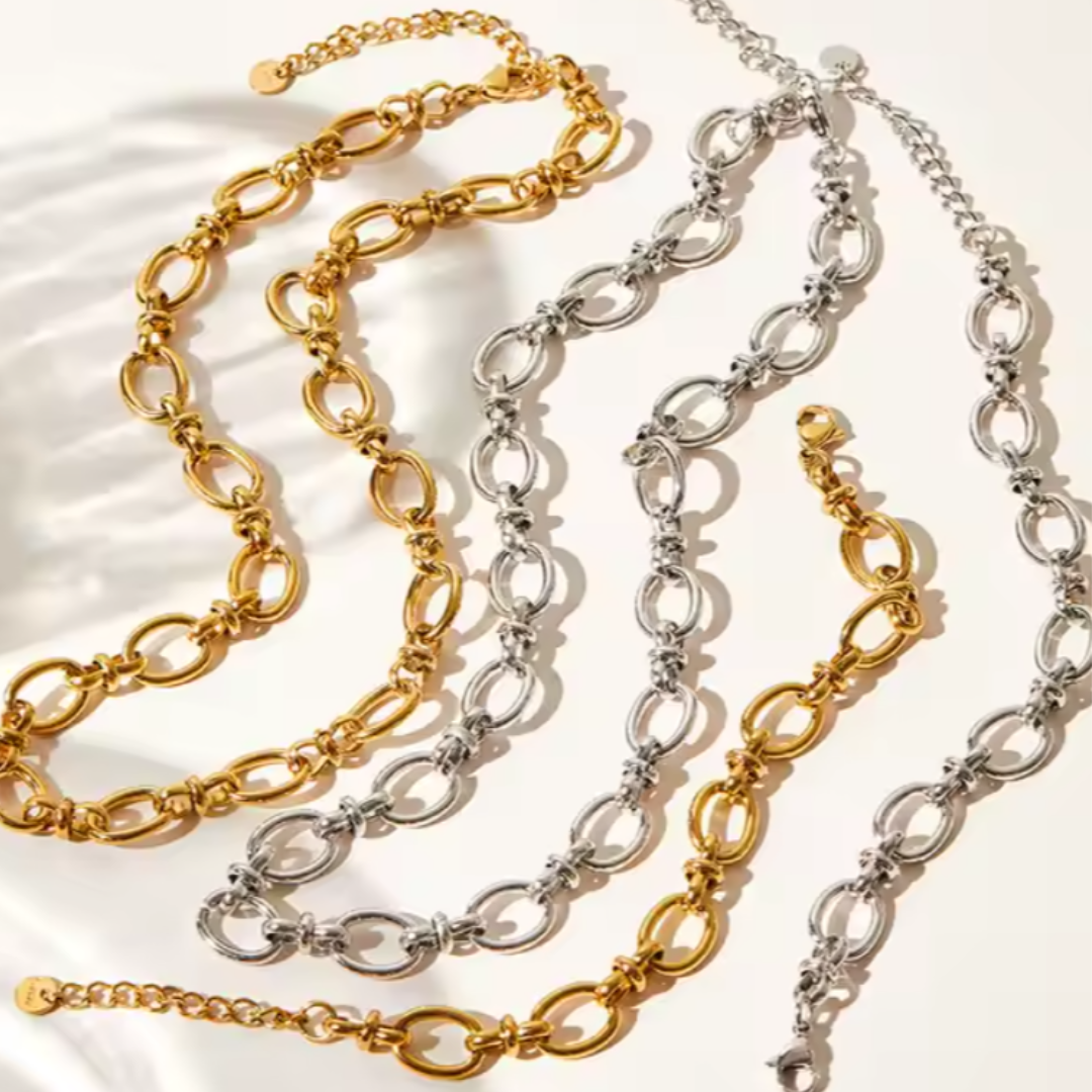 Two stainless steel 18k gold and silver plaited chain necklaces on a light background.