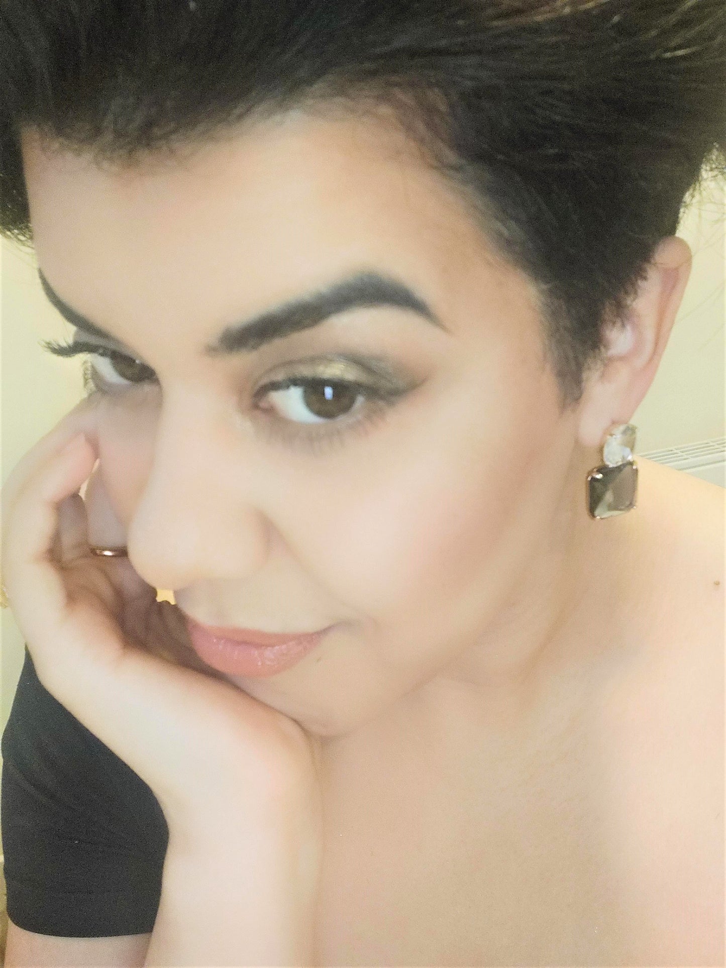 A pair of upcycled gold plated blue lux drop earrings on a pretty girl.