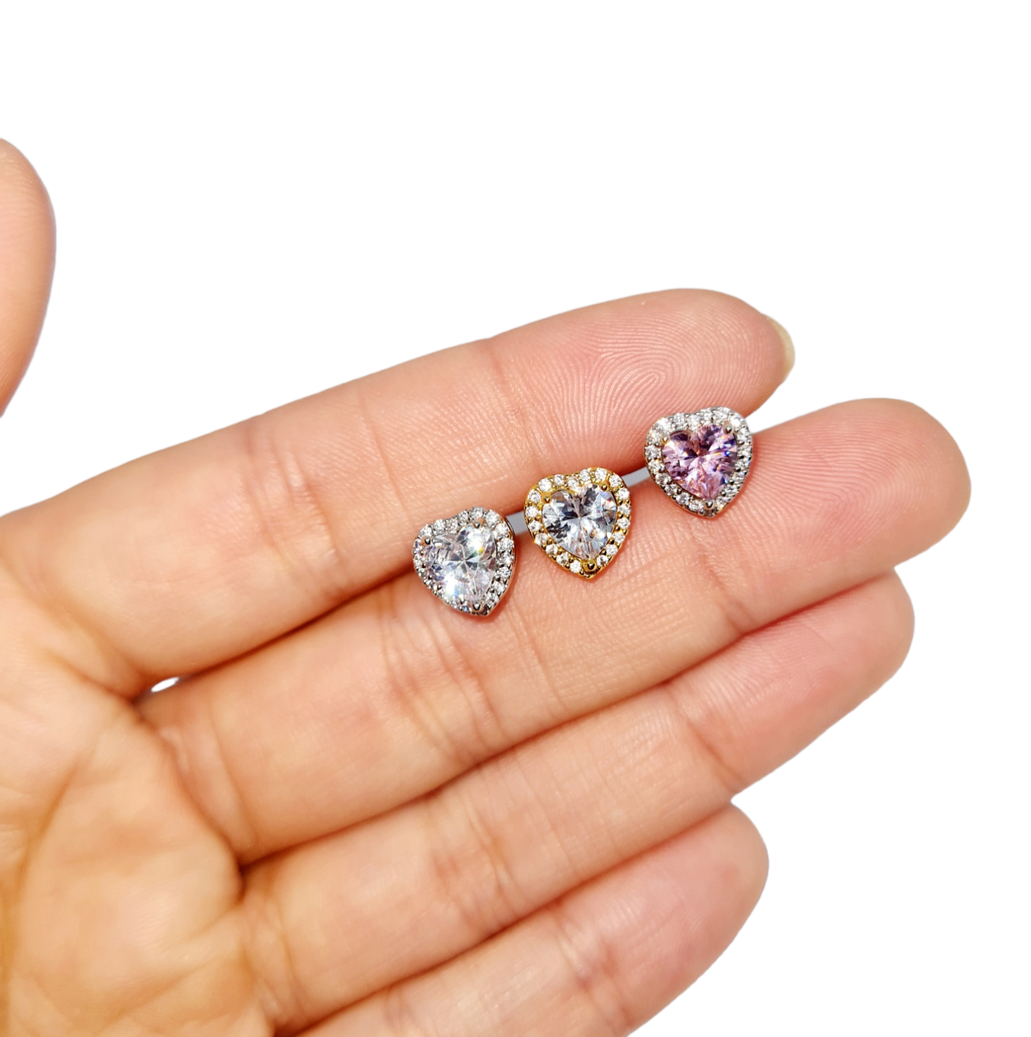 14k Plated Sweetheart Stud Earrings held in a hand on a white background.