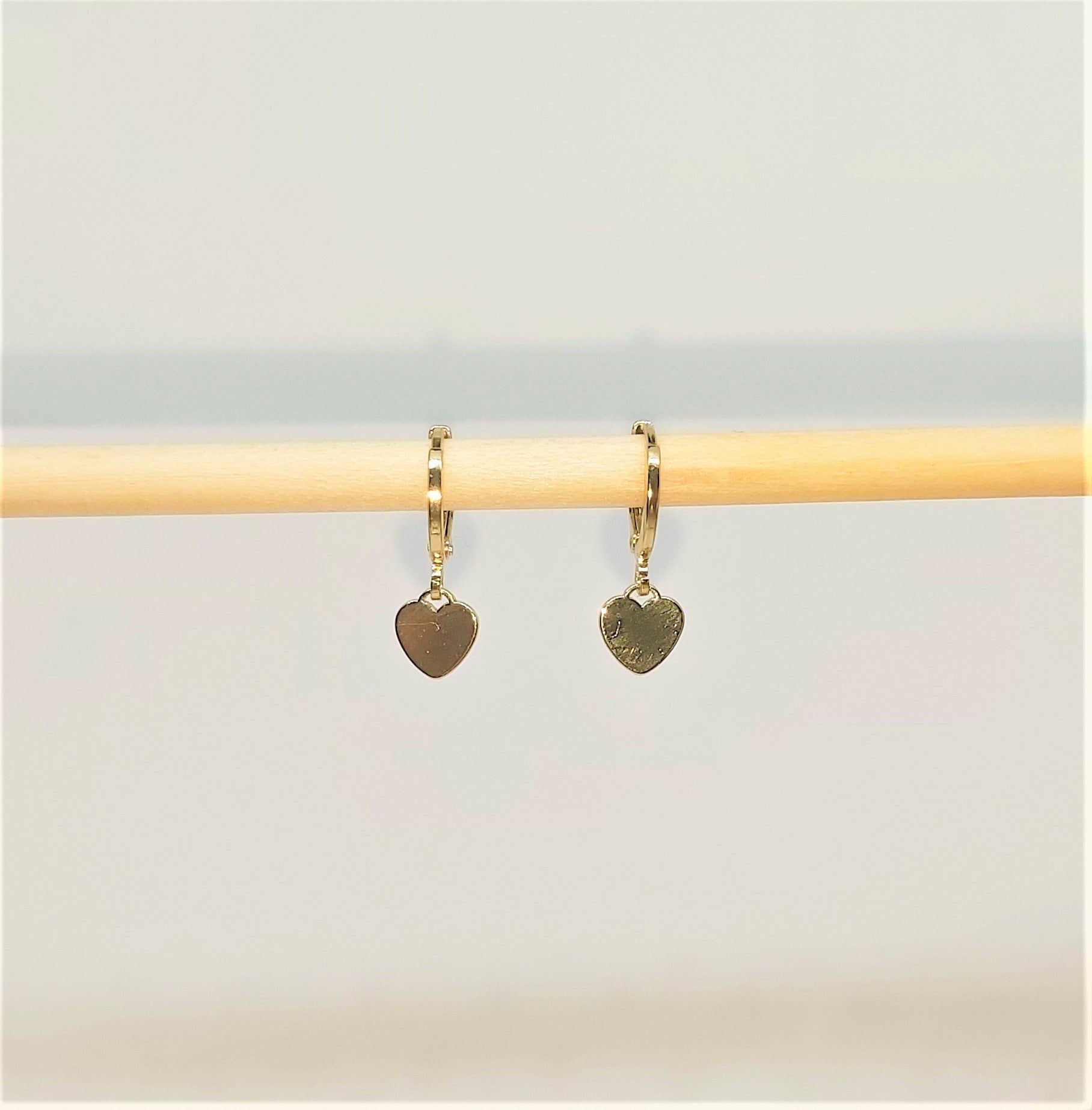 Gold Plated Heart Huggie Earrings with a white background.