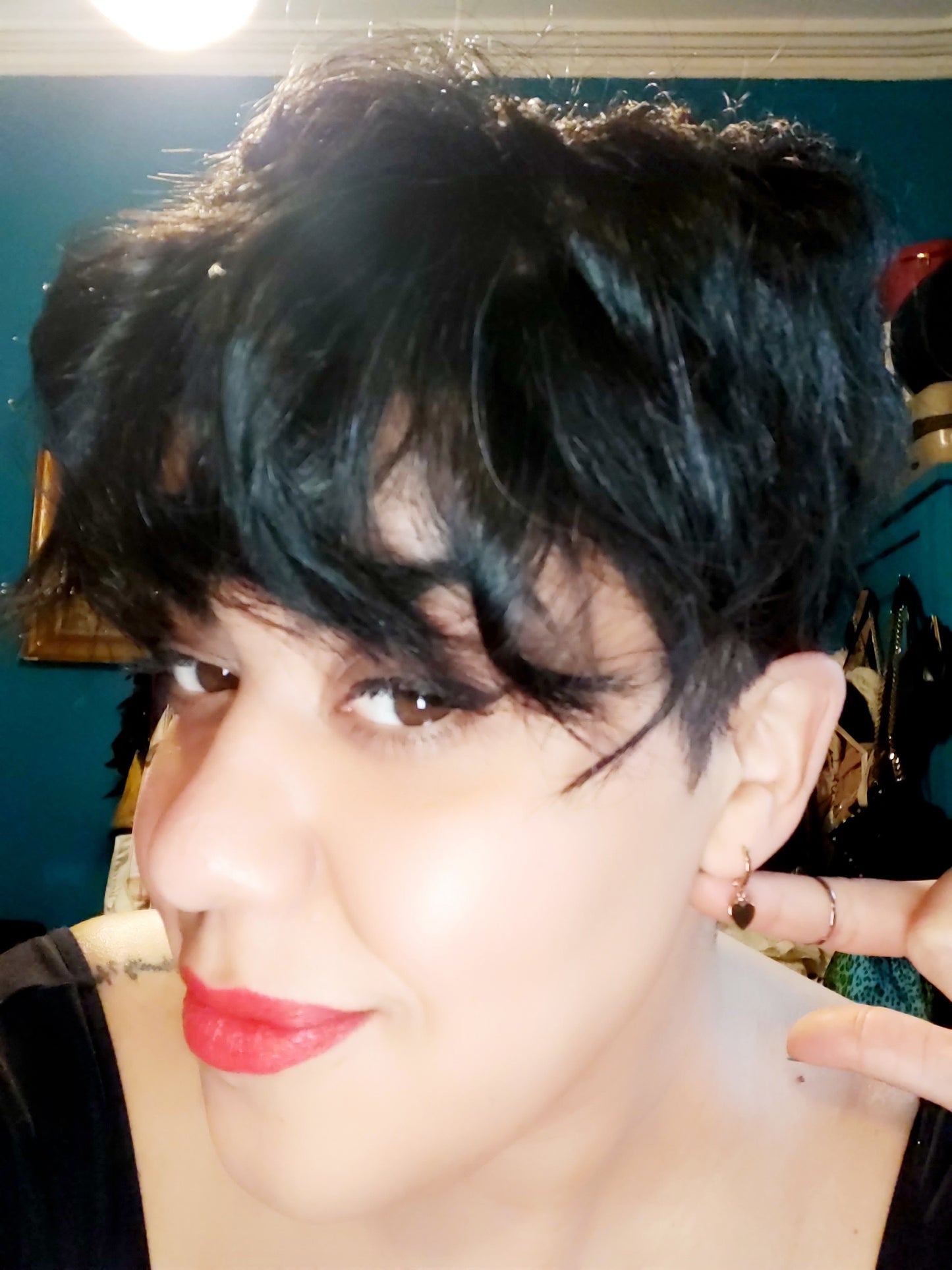 Gold Plated Heart Huggie Earrings on a pretty girl with short hair.