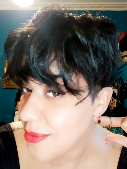 Gold Plated Heart Huggie Earrings on a pretty girl with short hair.