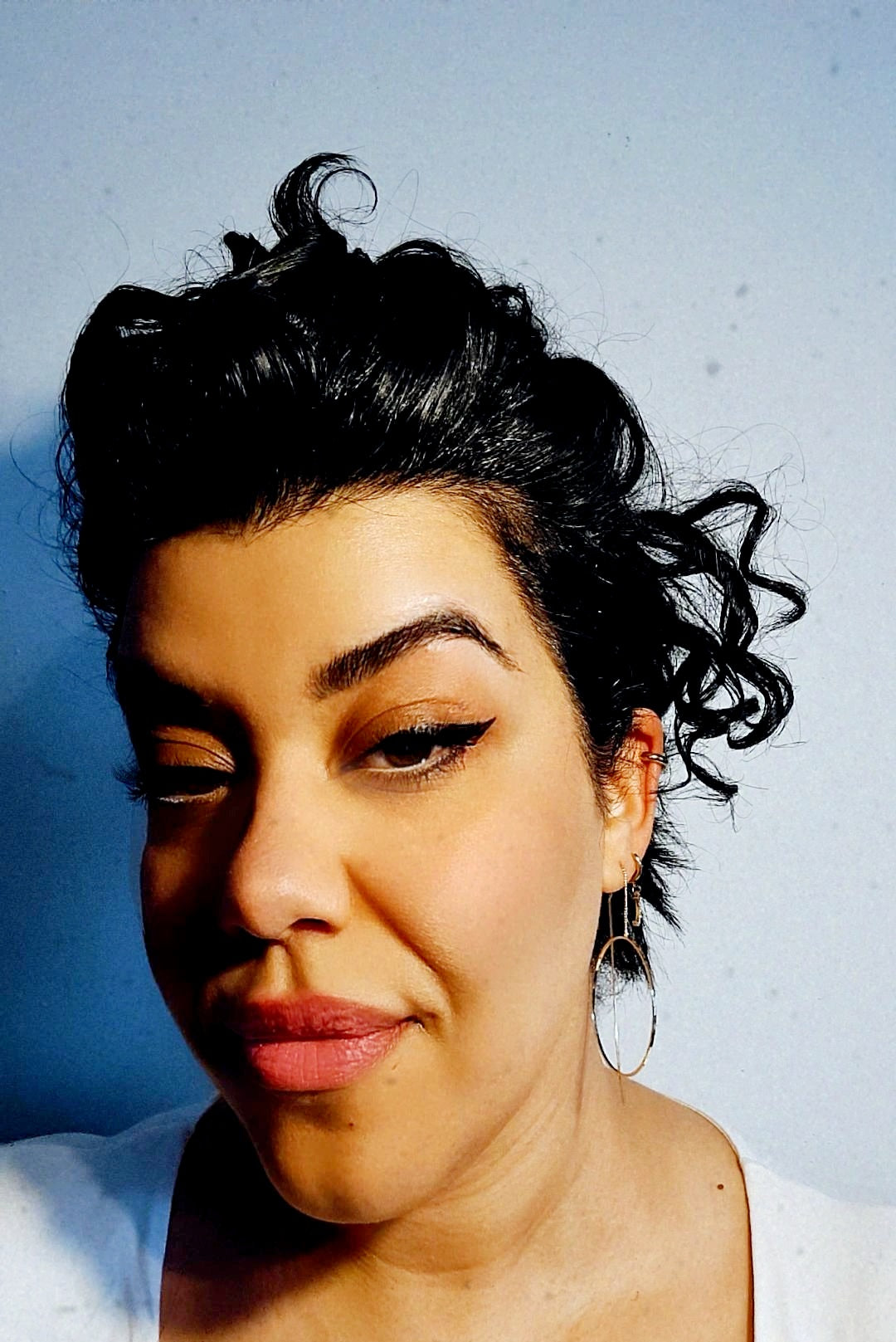 A pair of gold-plated circle pull-through earrings on a pretty girl.