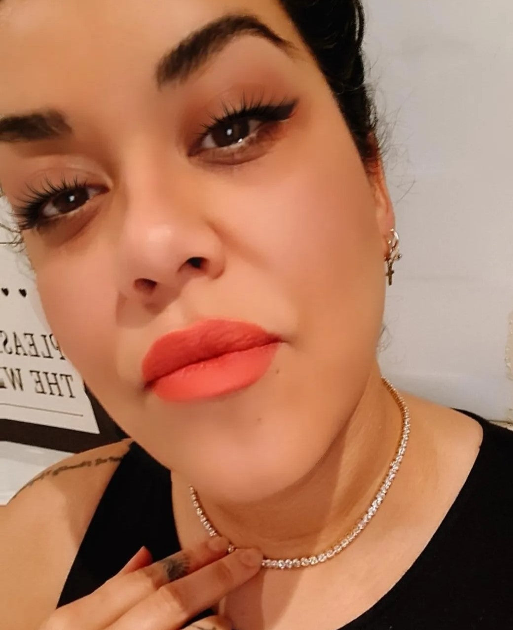 A pretty girl wearing a sparkle stoned necklace in a white room.