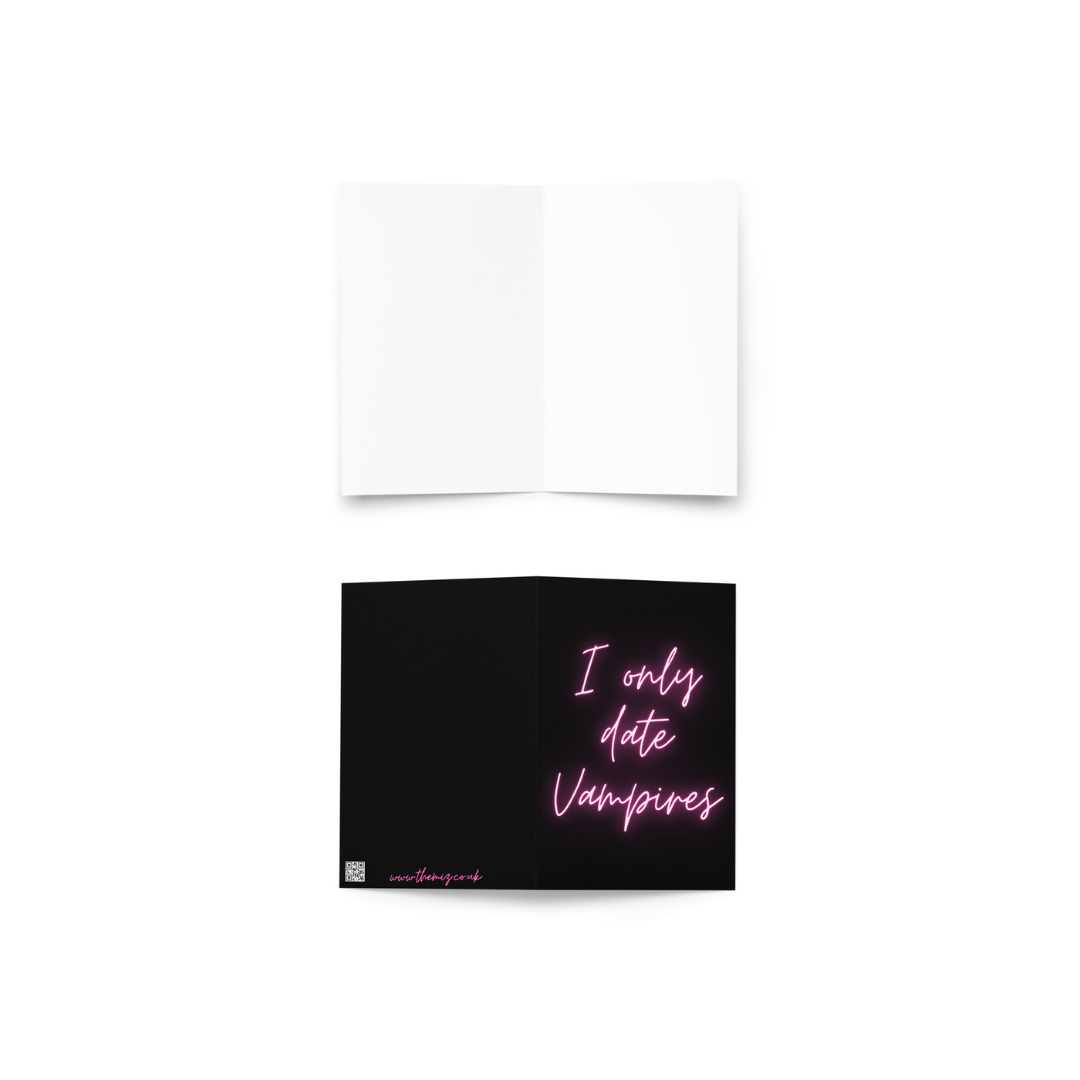 Greeting card with pink neon text saying 'I only date Vampires' on a black background.