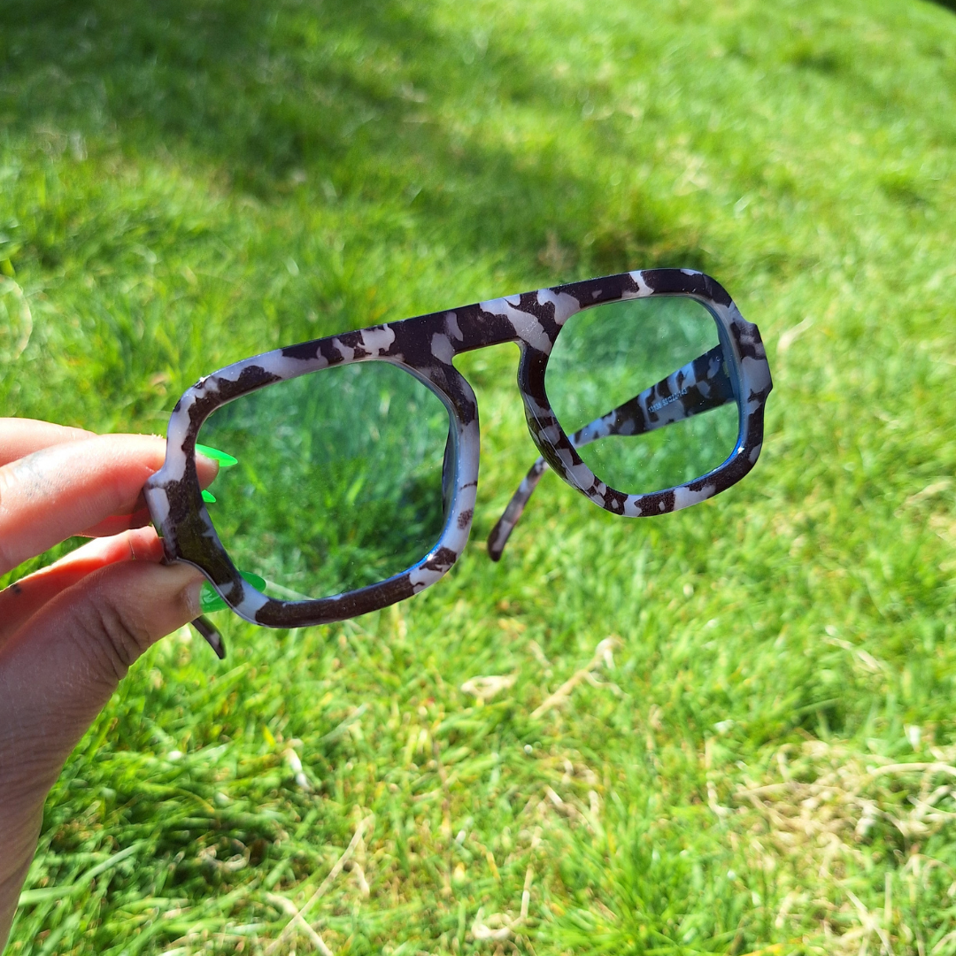Marble Blue Lensed Retro Sunnies being held up in the sun.