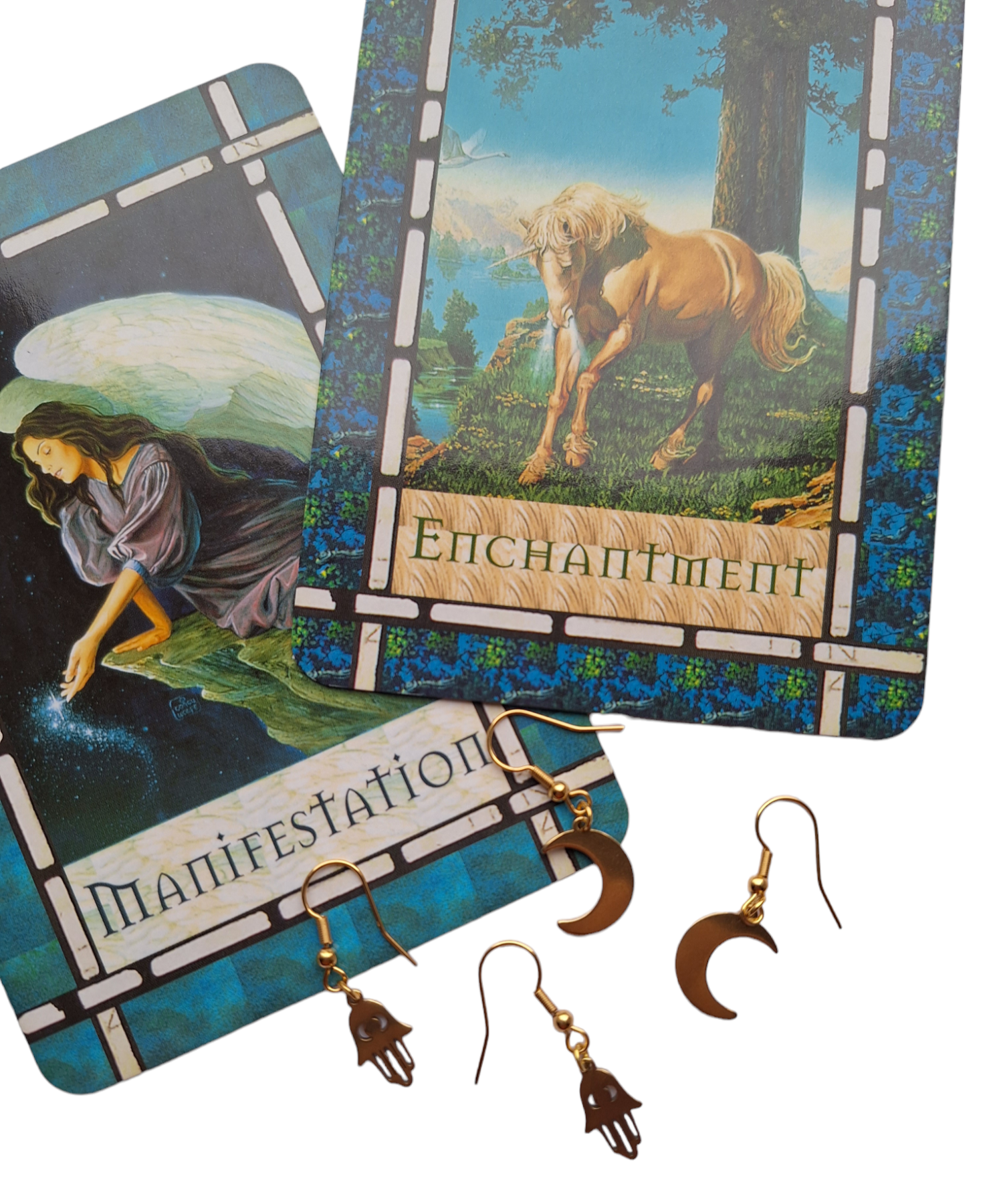 Celestial Moon and Fatima Hand Gold Plated Drop Earrings on a white background laid on some tarot cards.