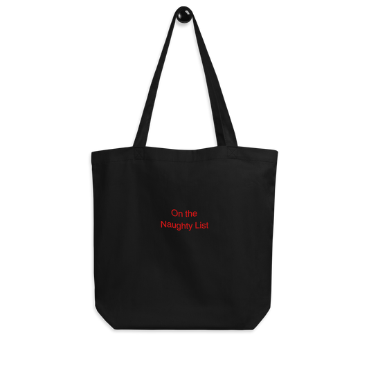 Organic Cotton Tote Bag in black with a slogan at the front that says on the naughty list embroidered in red thread on a white background.
