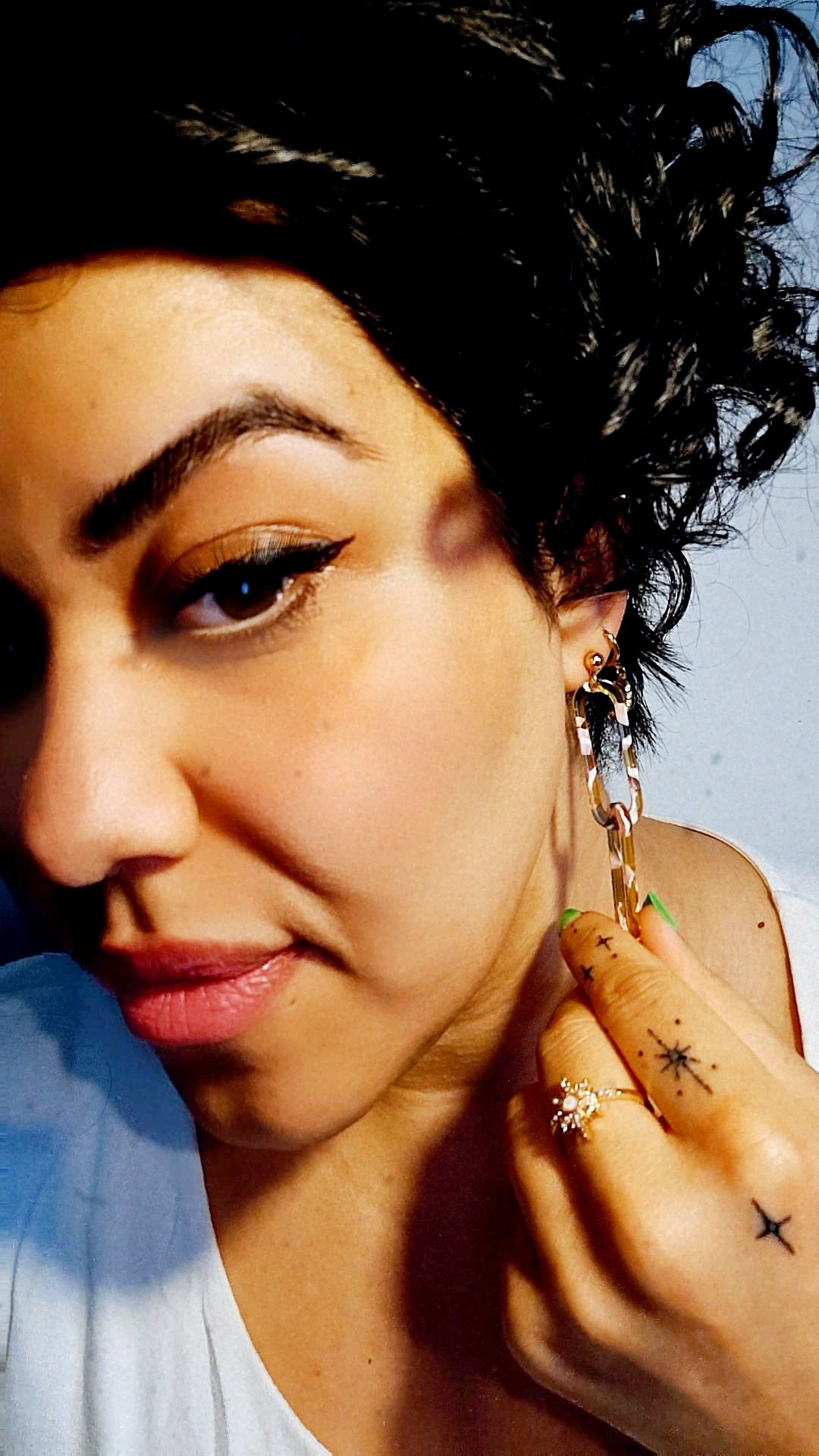 Recycled Summer Rose Link Resin Drop Earrings featuring a geometric rose-shaped design in a translucent yellow and pink resin with gold plating on a pretty girl.