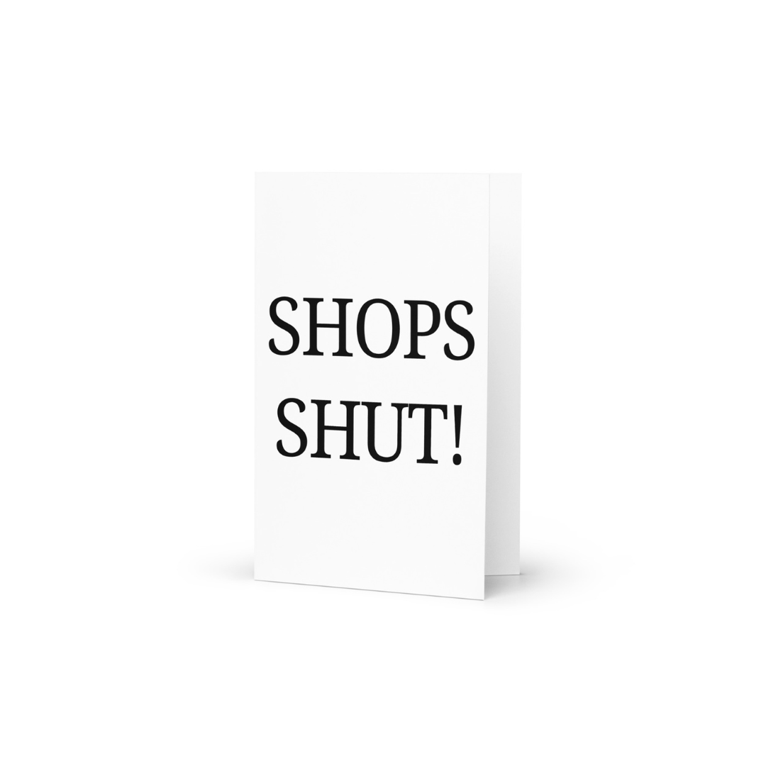 A white greeting card with the funny phrase Shops Shut! in black capital letters.
