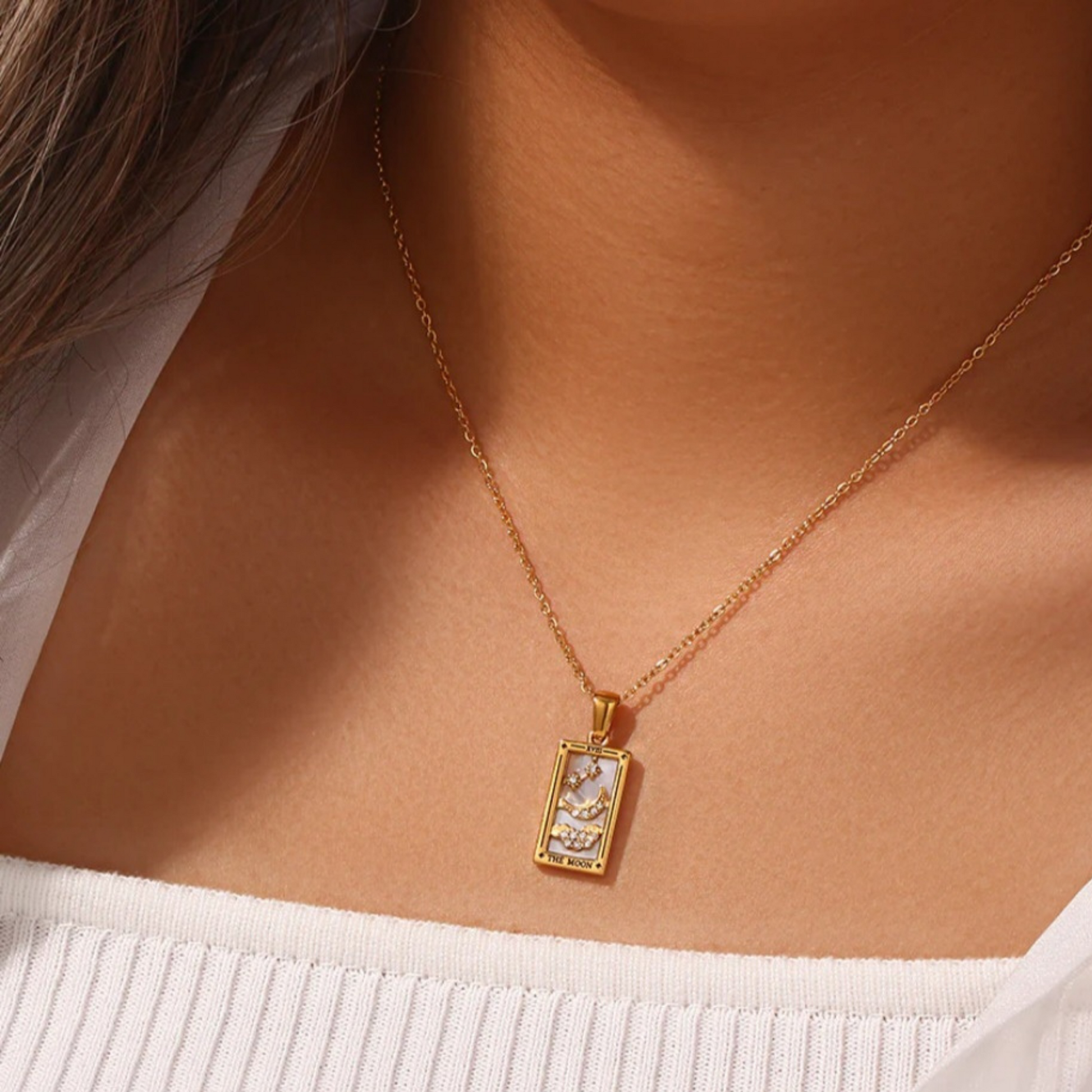 An 18K gold plated tarot card necklace with a pendant featuring 'The Moon' card design and a chain extension.