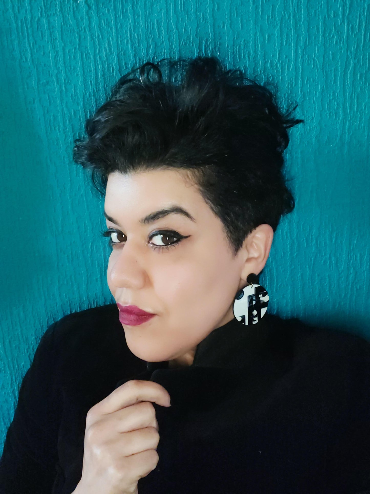 Upcycled Black and White Resin Drop Earrings on a pretty girl with a green background.