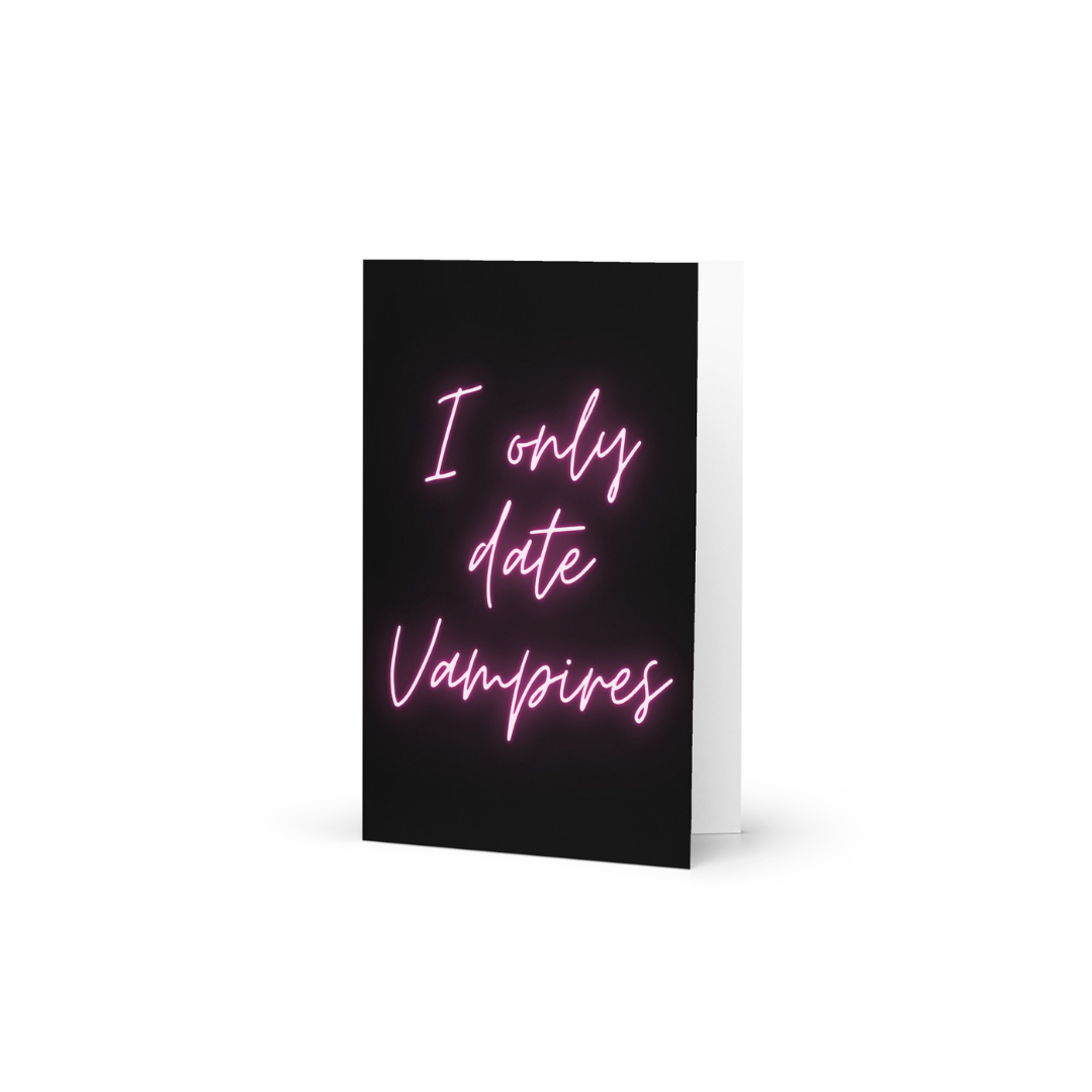 Greeting card with pink neon text saying 'I only date Vampires' on a black background.