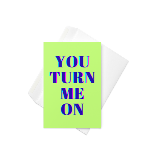 A neon green greeting card with the words You Turn Me On at the front in big bold navy letters with a white envelope also.