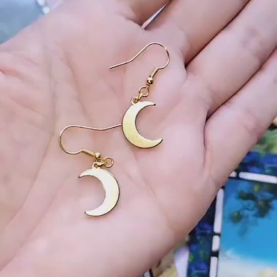 Celestial Moon Drop Gold Plated Earrings on a hand.