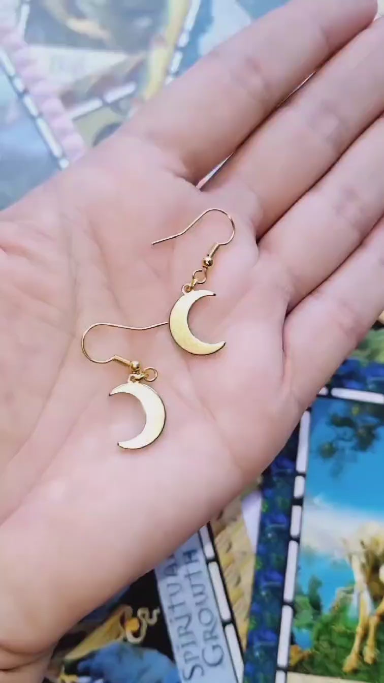 Celestial Moon Drop Gold Plated Earrings on a hand.