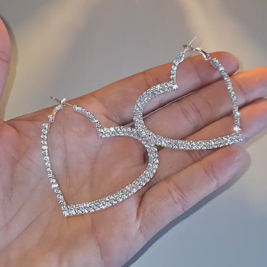 925 Silver Plated Sparkle heart hoops held in a hand so you can see the sparkle.