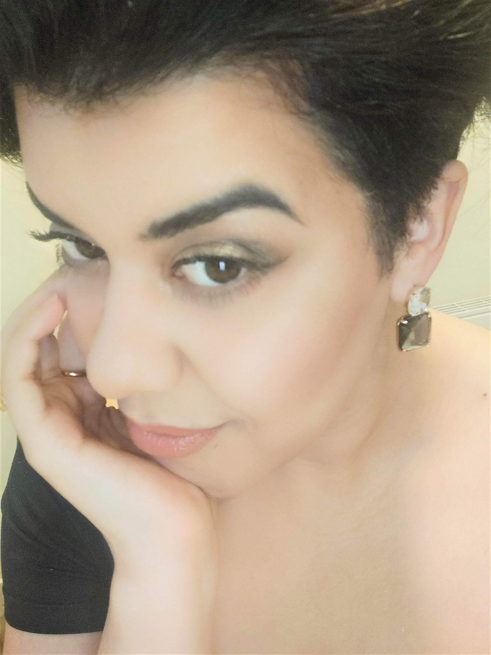 A pair of upcycled gold plated blue lux drop earrings on a pretty girl.